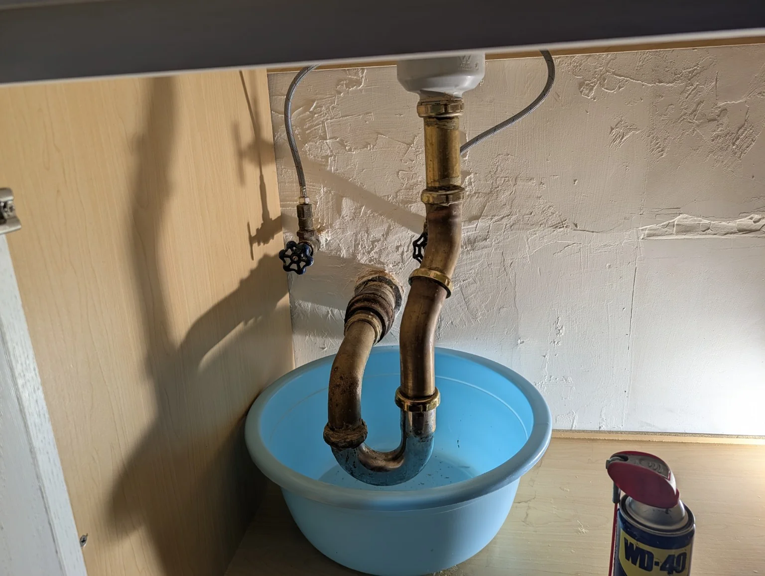 Emergency leak repair under a sink with exposed drain piping