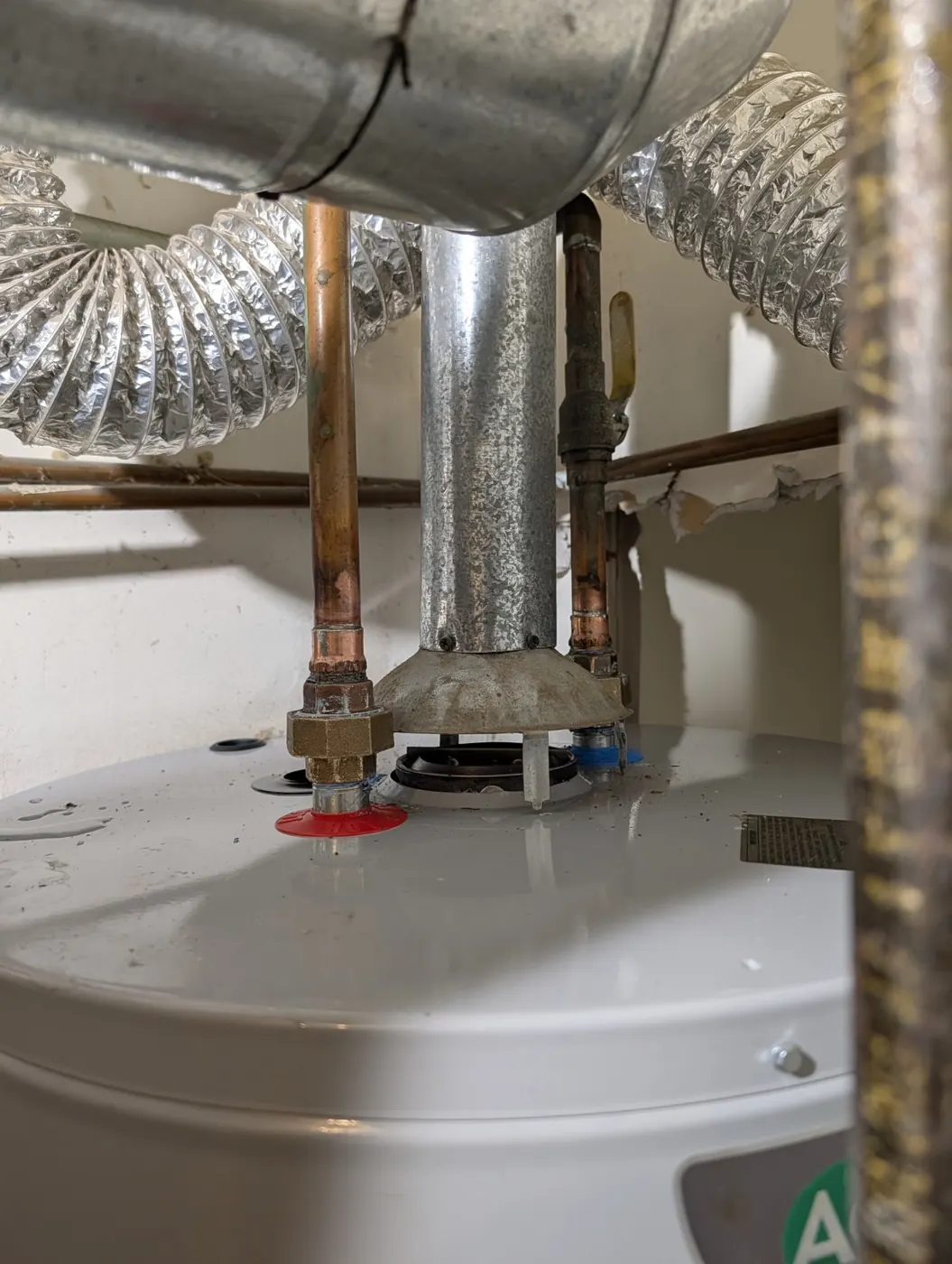 Newly installed water heater with copper hot and cold water connections and vent piping