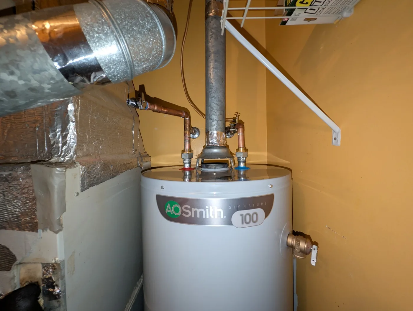 Newly installed A.O. Smith water heater with copper piping and vent connection